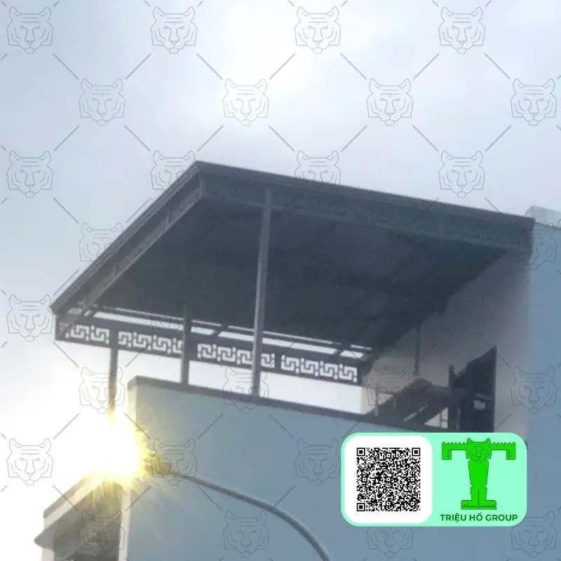 Mái che bằng tấm lợp kim loại màu tối trên ban công một ngôi nhà, có ánh nắng chói chang
