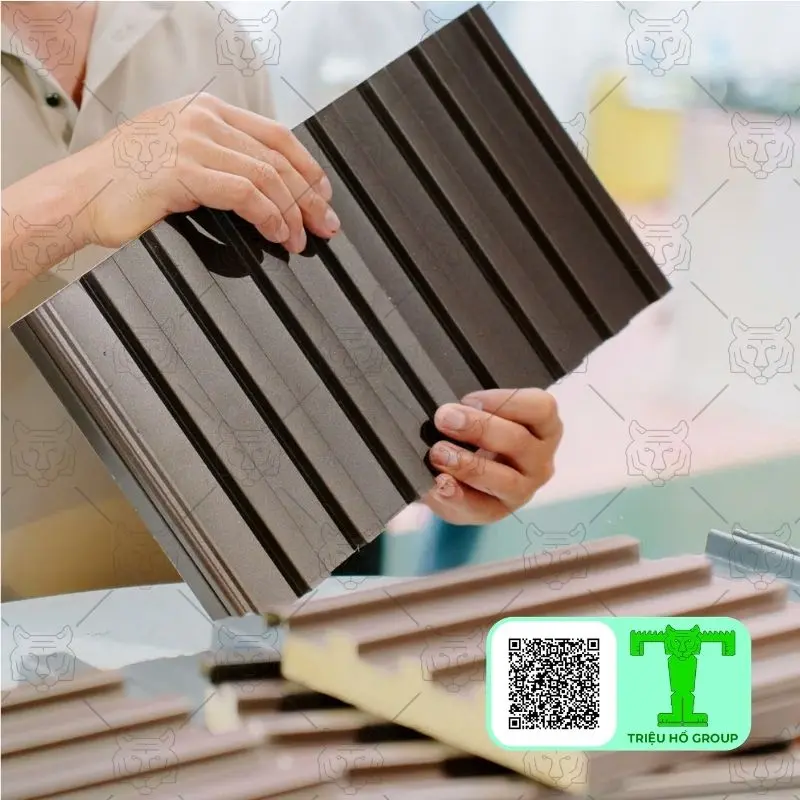 Mẫu tấm lợp hợp kim nhôm màu nâu sẫm với các đường gân nổi được một người cầm trên tay